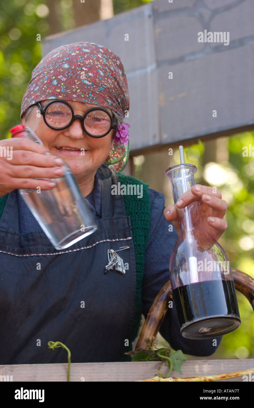Old lady drinking wine at winemaking show at Lipica stud farm Stock