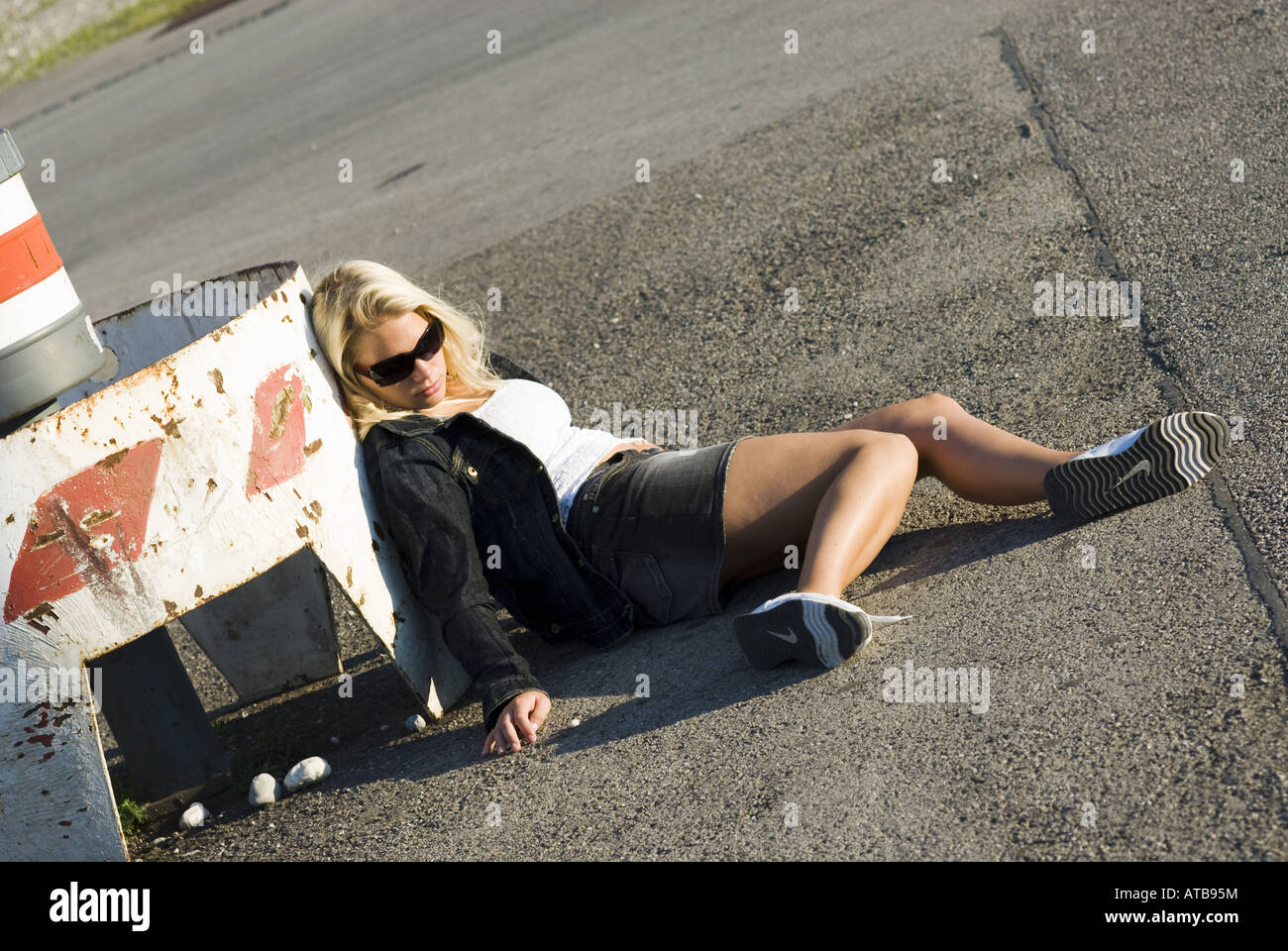 drug addicted women lying on the asphalt Stock Photo, Royalty Free