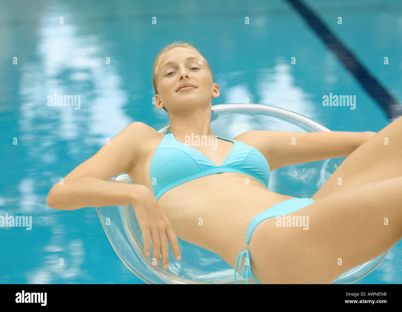 Woman In Bikini Lounging In Transparent Chair By Pool Stock Photo Alamy