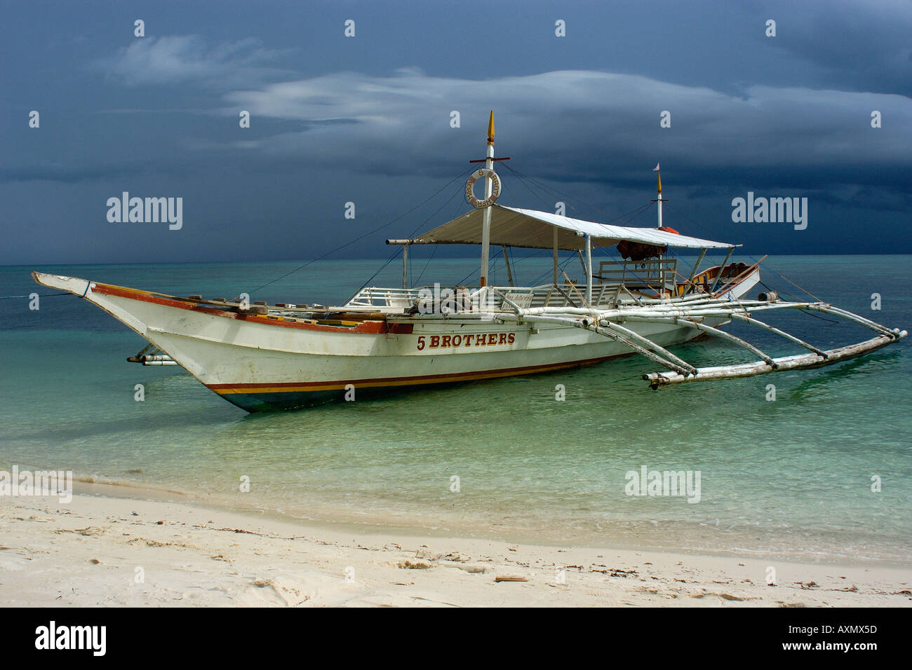 Bangka or traditional Philippino boat rests near shore 