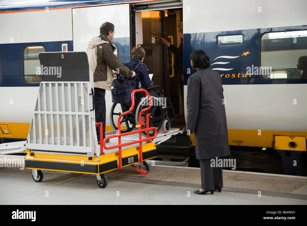 Wheelchair passenger boarding Eurostar train by the means of a ramp Stock Photo, Royalty Free