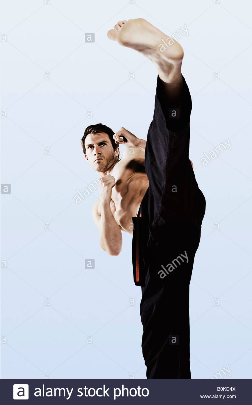 Man practicing martial arts and kicking Stock Photo, Royalty Free Image