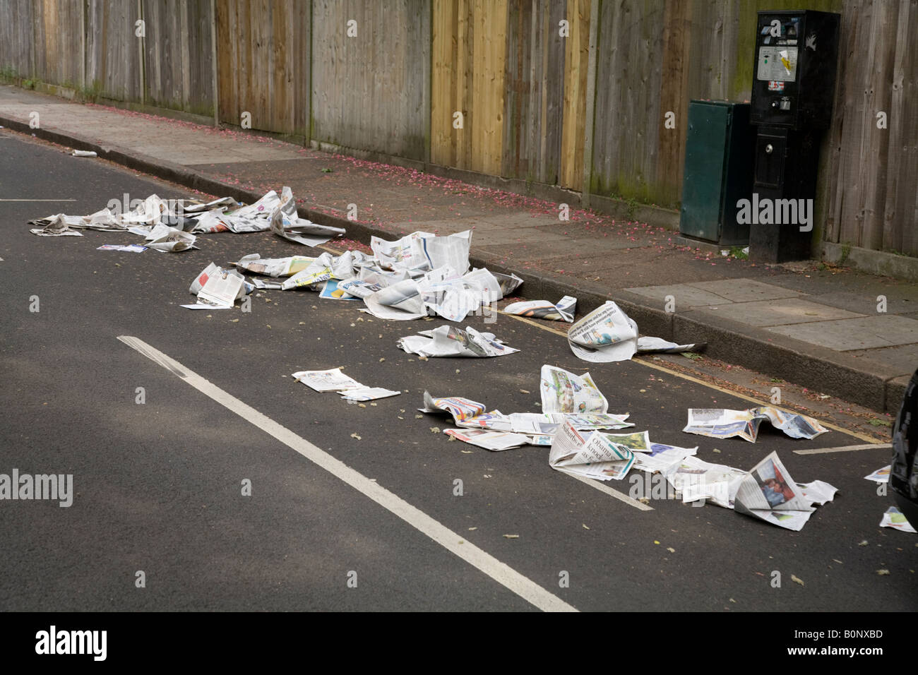 Newspaper and litter blowing down the road after it was placed for