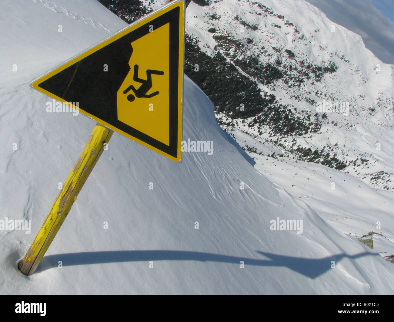 Sign in snowy mountain scenery of a skiing area warning against Stock