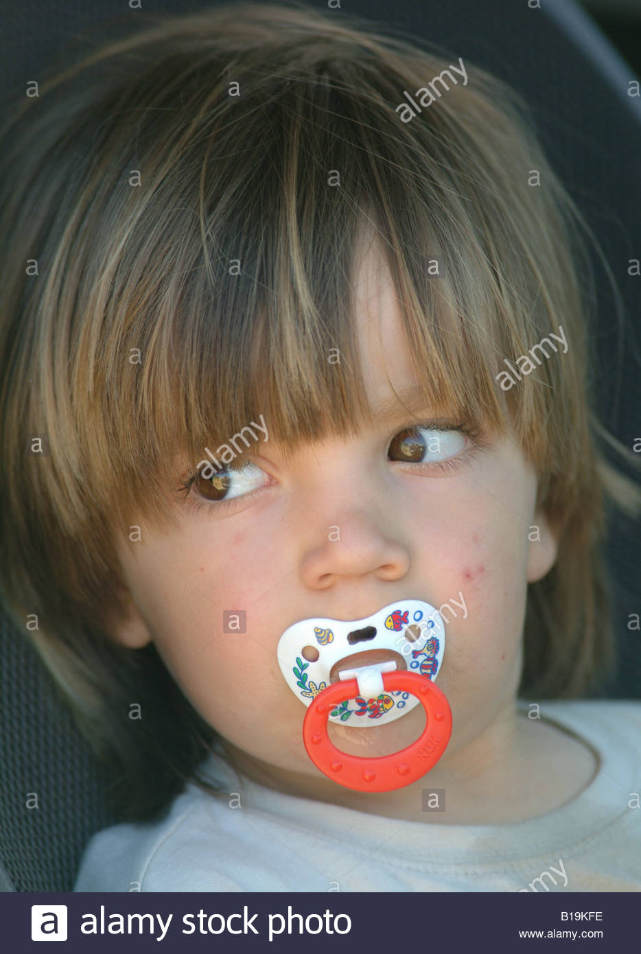 childs face with dummy in mouth little boy pacifier Portrait of an Stock Photo, Royalty Free