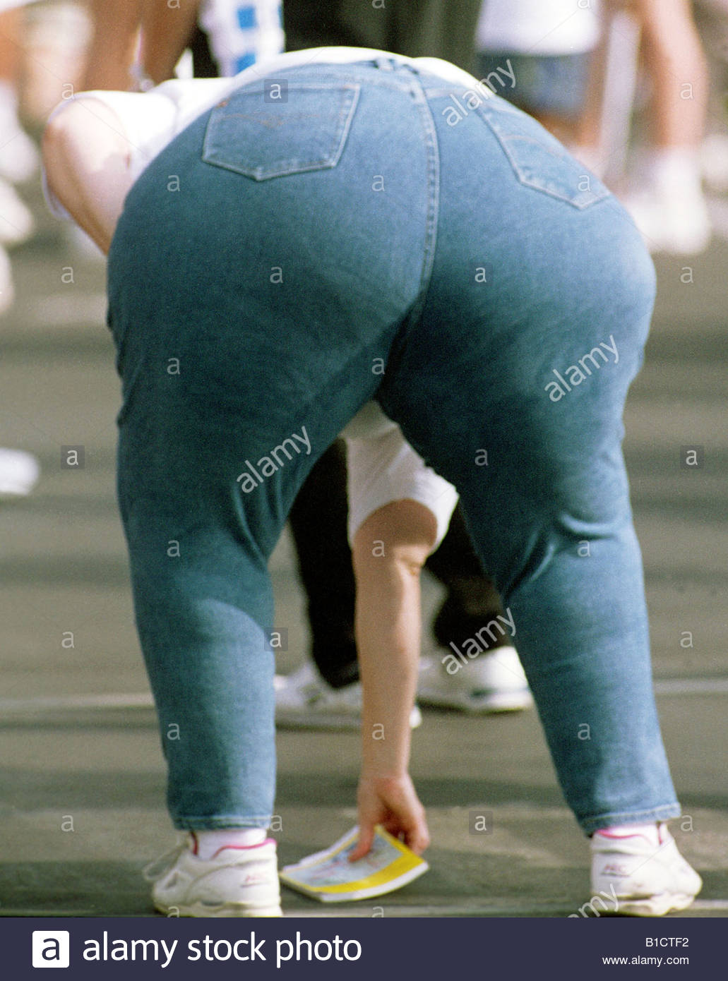 Obesity Fat Lady Bending Over Wearing Blue Denim Jeans Rear View Stock