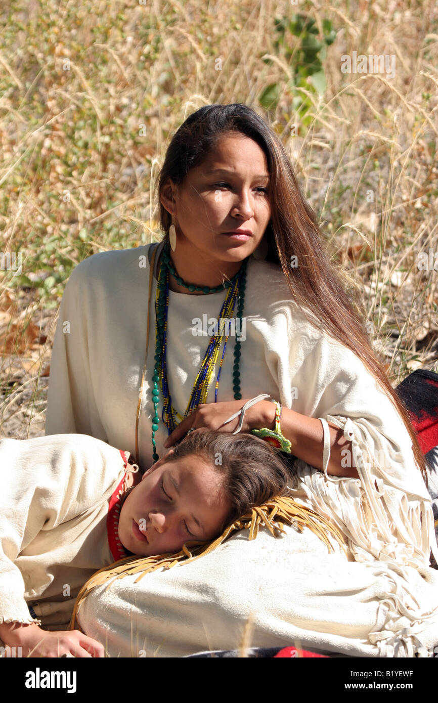 Young Native American Sioux Indian mother and daughter sitting on a