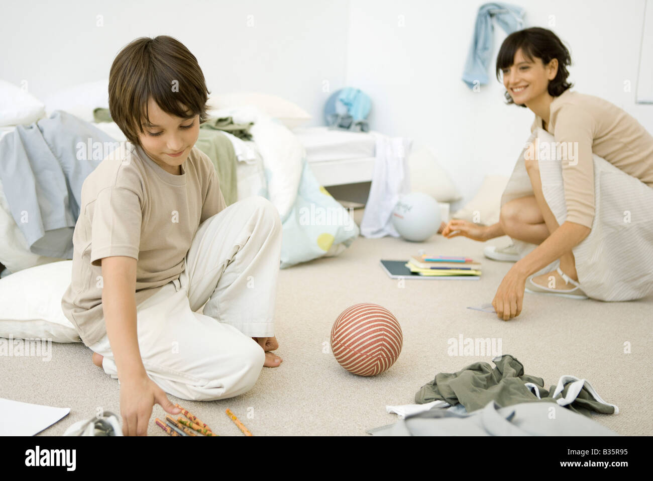 Cleaning Messy Room mother and son crouching down to clean up messy room stock photo Cleaning Messy Room mother and son crouching down to clean up messy room stock photo