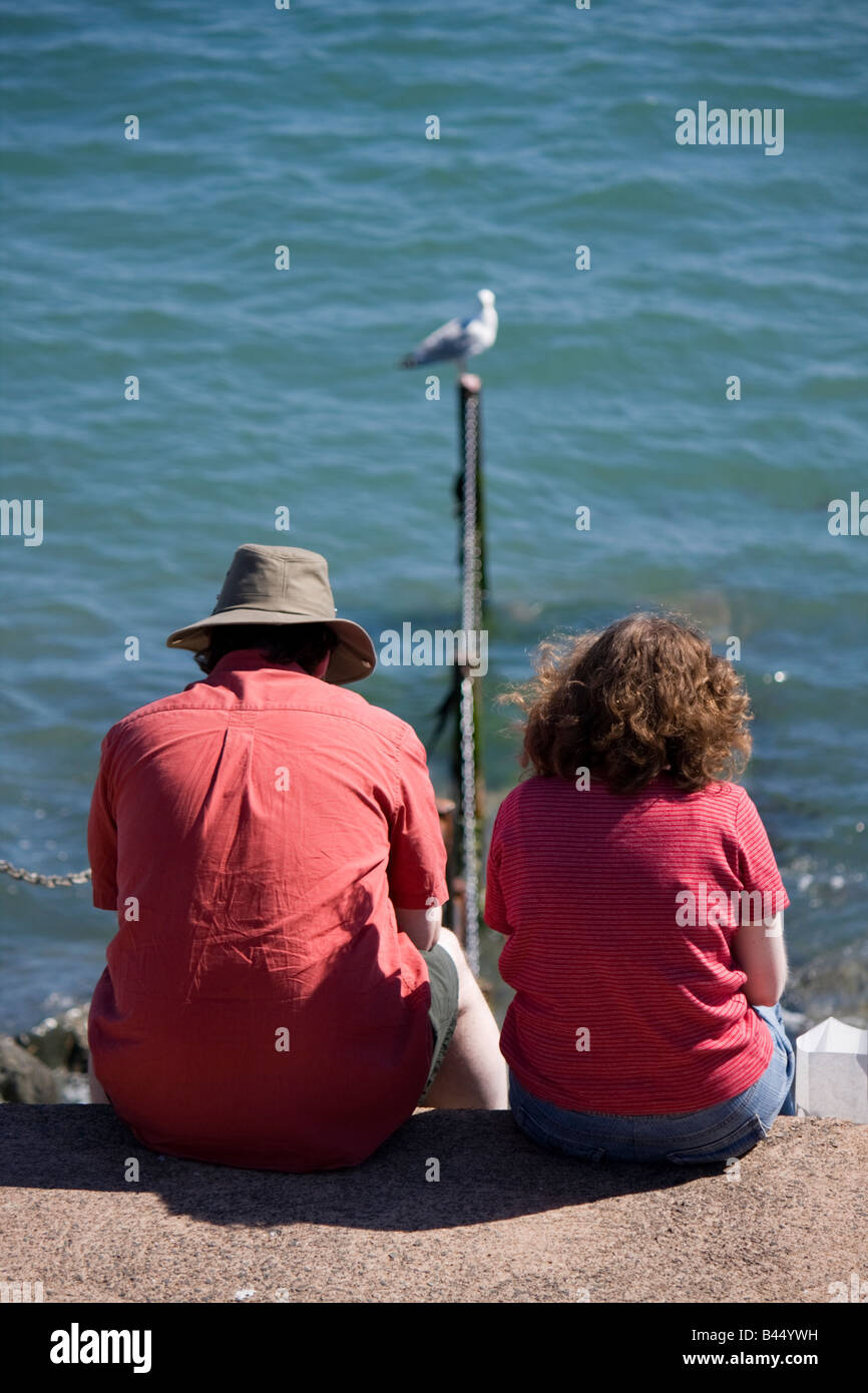 couple-sitting-beside-the-sea-lyme-regis