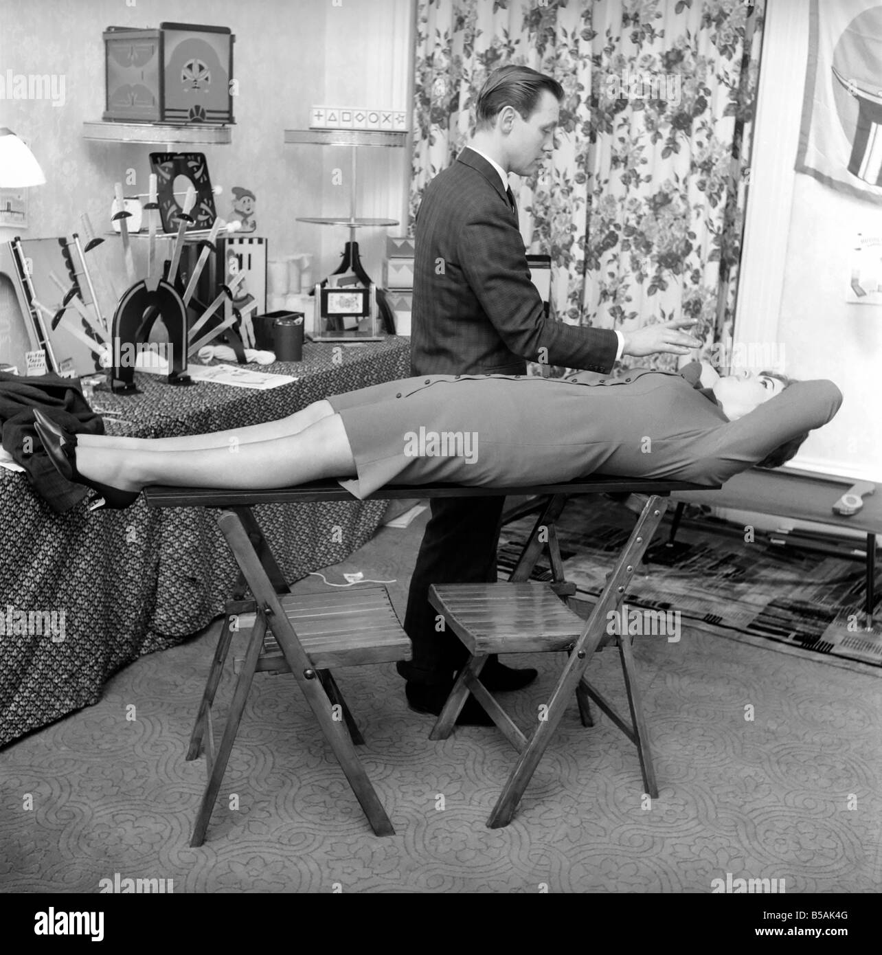 Magician Bernard Hughes Performing a levitation trick on his female