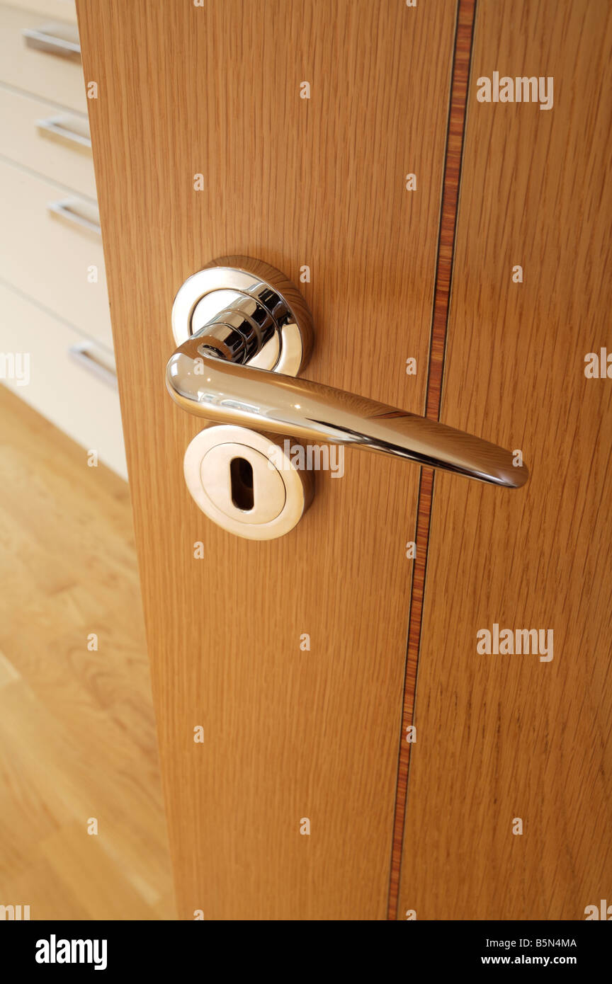 Chrome plated door handle and escutcheon on an inlaid oak veneered