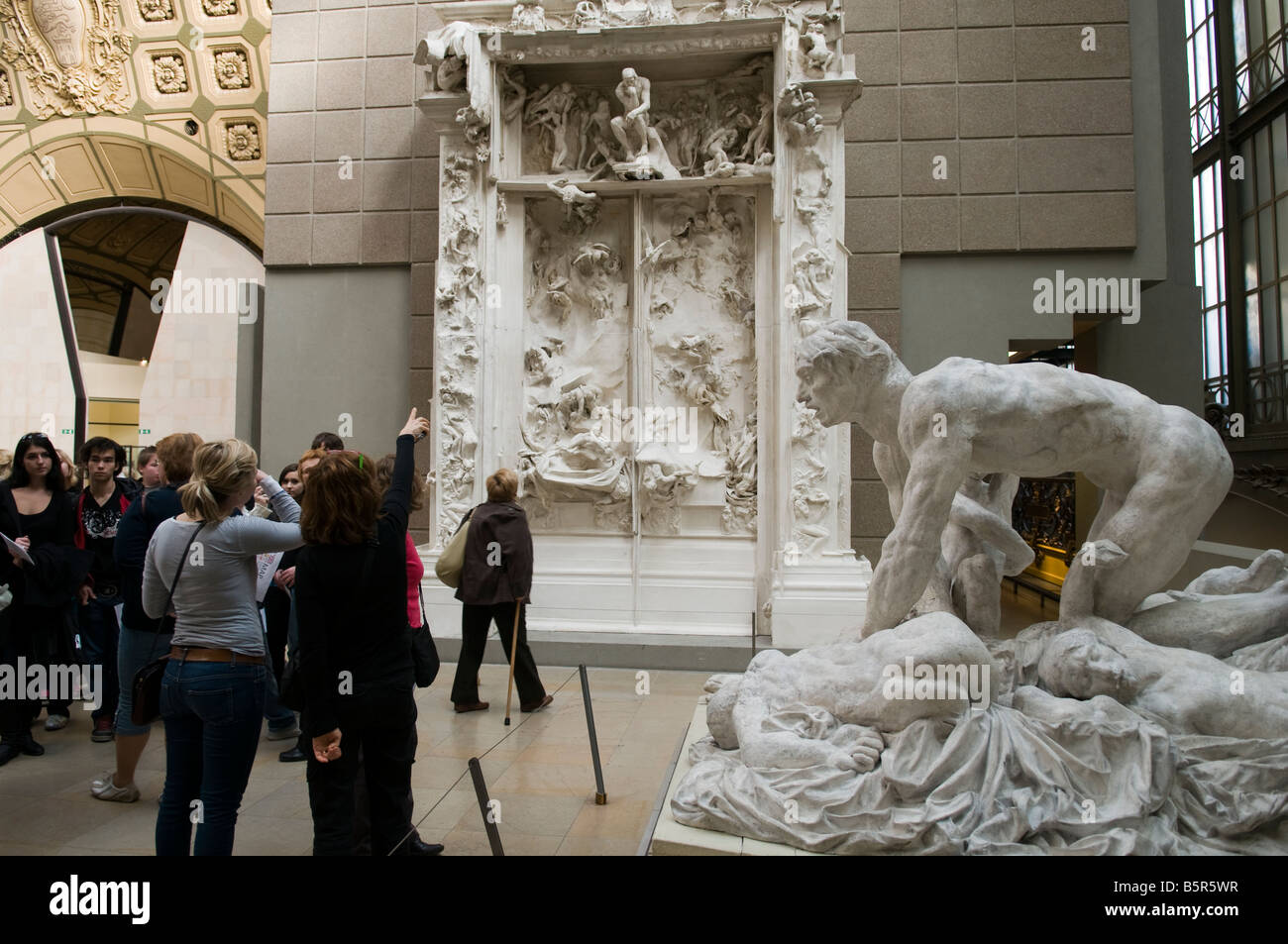 Visitors examining Rodin's Gate of Hell art, Musee d Orsay, Paris Stock