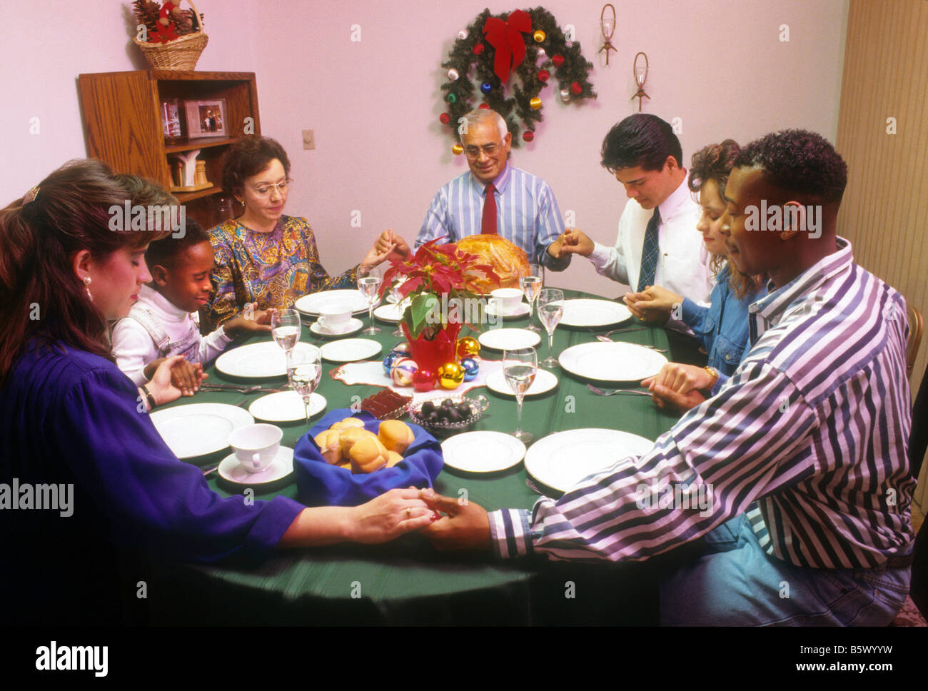 Mixed race family prays before Christmas dinner Stock Photo, Royalty