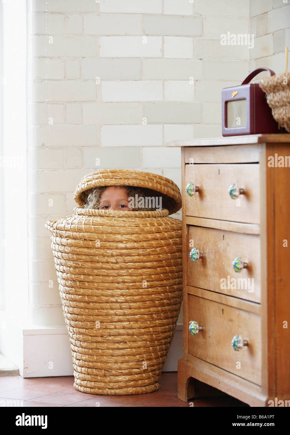 child-hiding-in-laundry-basket-B6A1PT.jpg