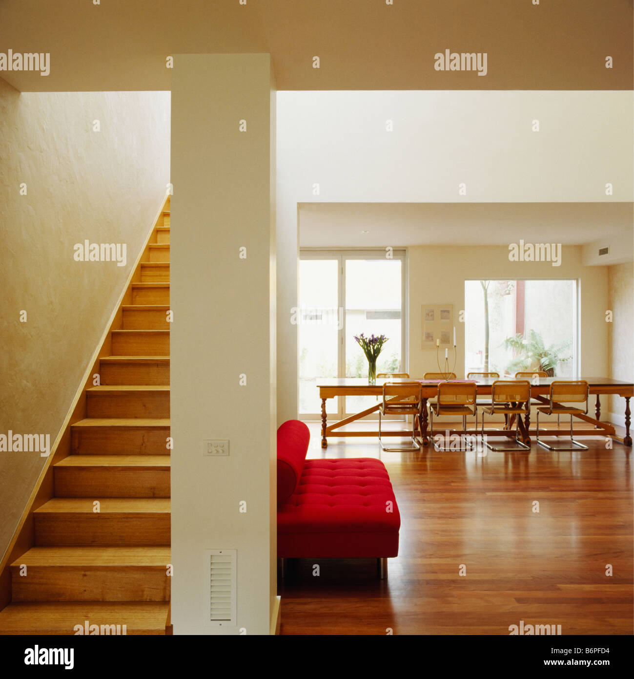 Wooden staircase in large modern openplan hall dining room with Wooden staircase in large modern openplan hall dining room with