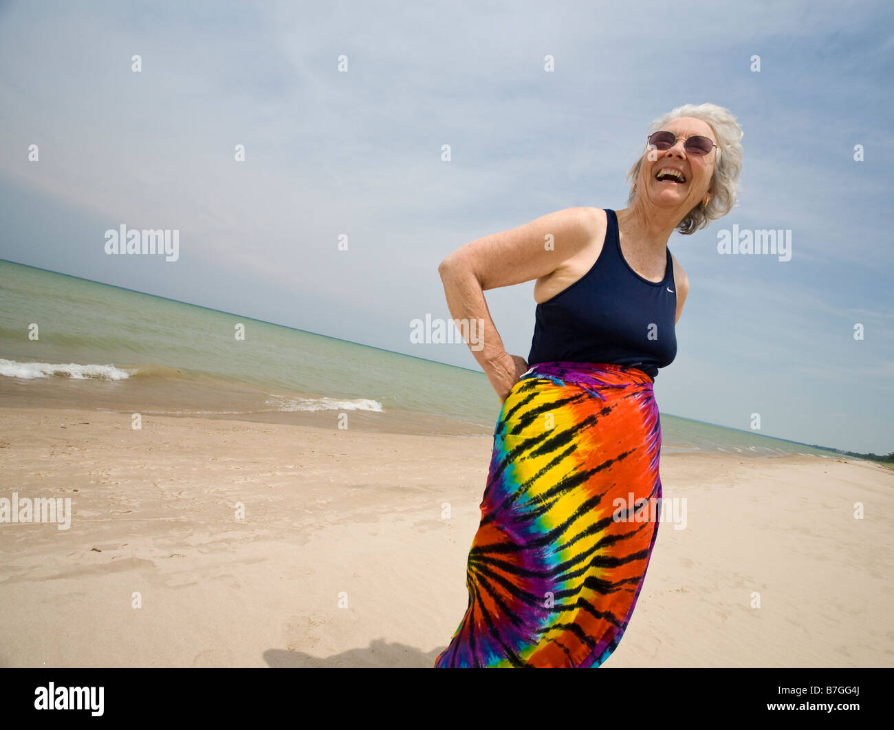 Happy on the Beach An older woman dressed in a bathing suit top and Stock Photo, Royalty Free