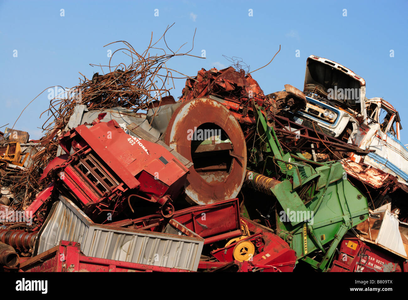 A massive pile of wrecked vehicles and machinery in a junkyard Stock