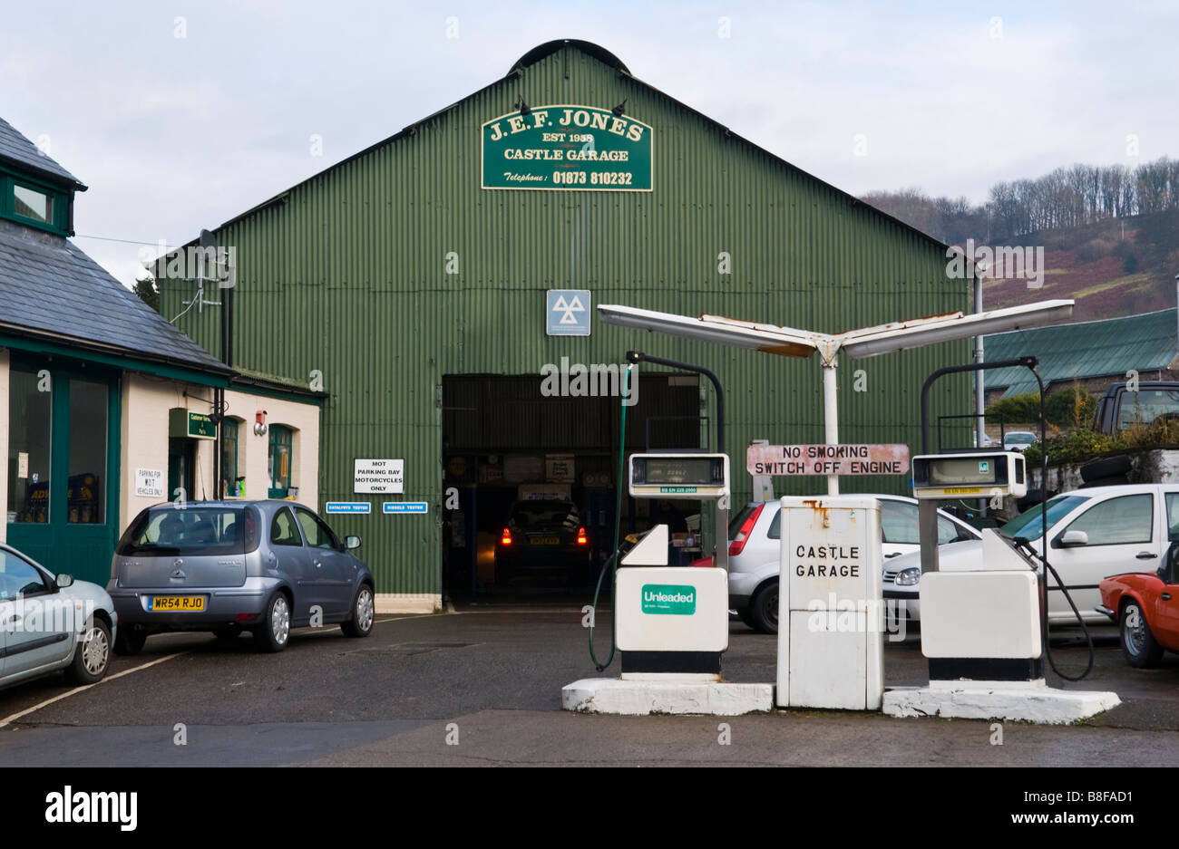 Exterior of local garage with old style petrol pumps and cars on Stock Photo, Royalty Free Image