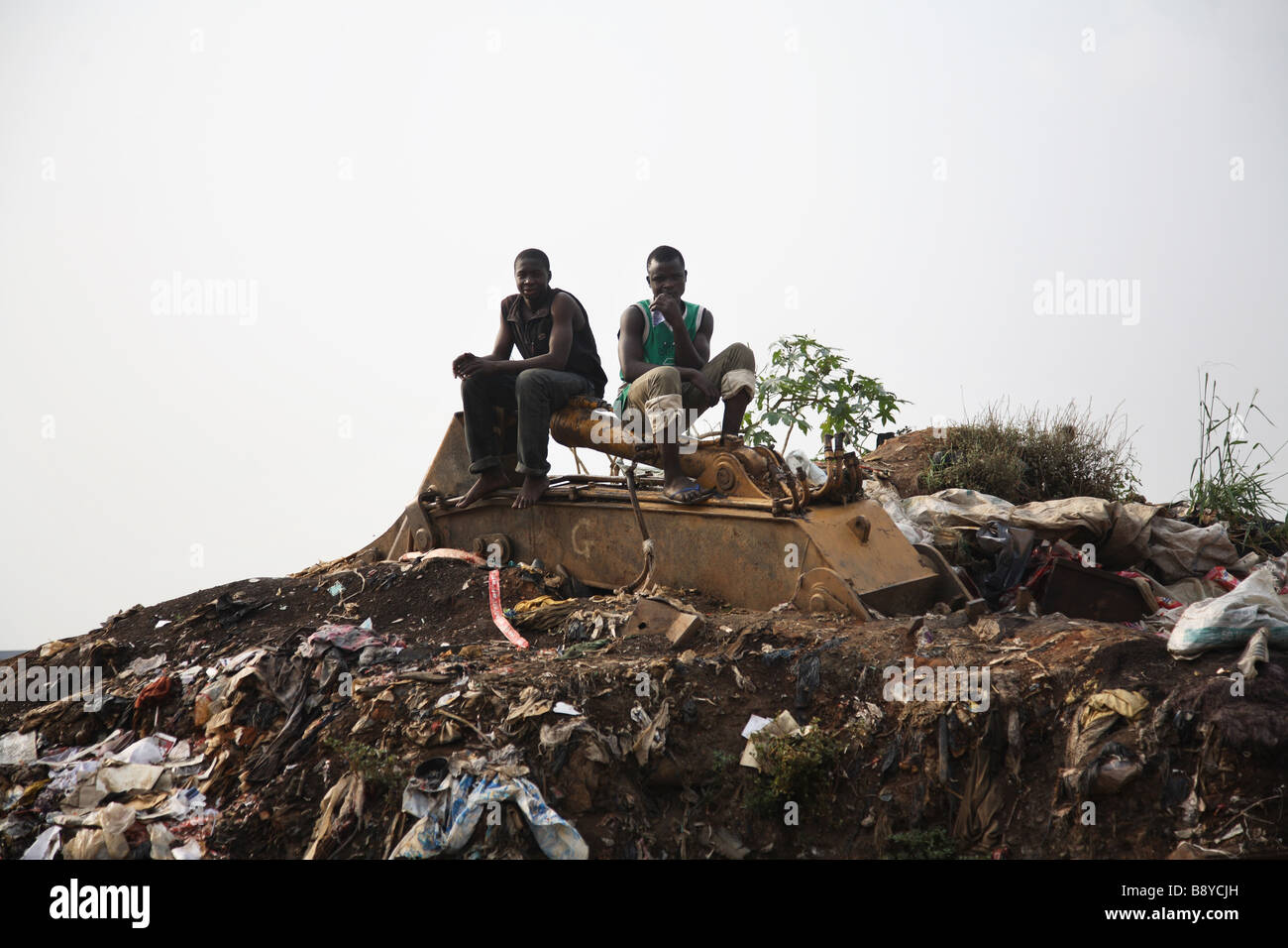 Two men are sitting on top of a mountain of rubbish in Olusosum ... Two men are sitting on top of a mountain of rubbish in Olusosum ...