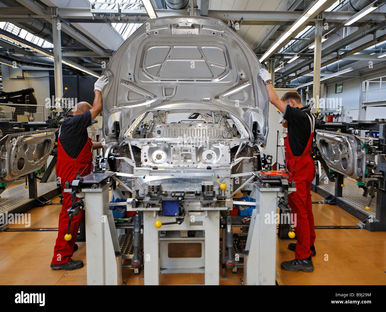Car body workers assembling a onto an R8 car body at Audi R8