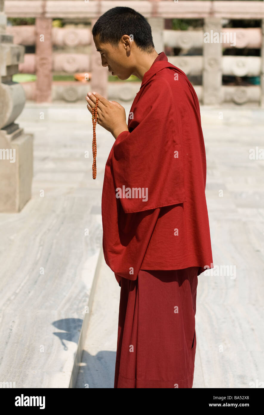 A Buddhist Monk Praying At The Mahabodhi Temple In Bodhgaya Stock Photo