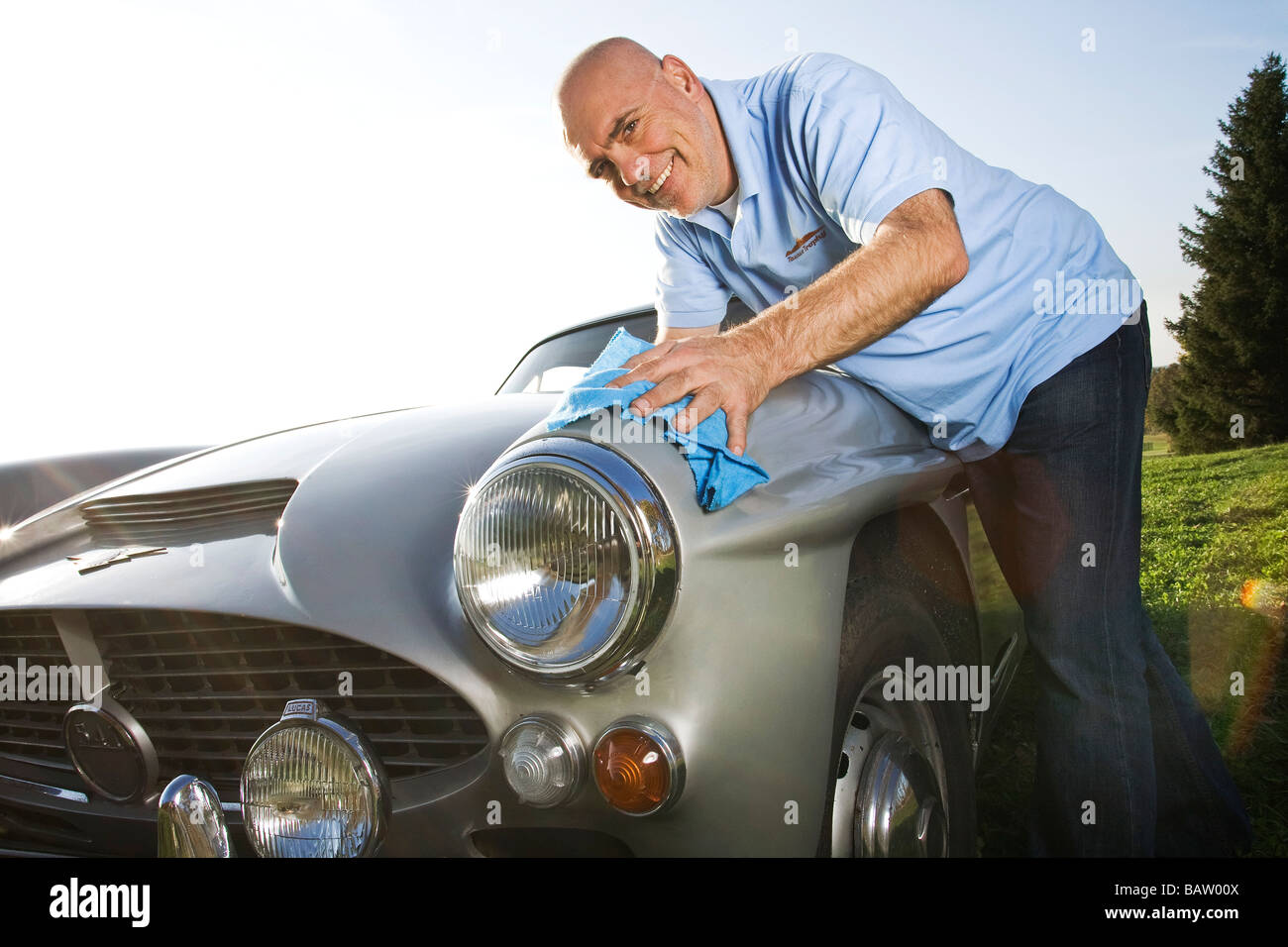 man polishing his classic car with cloth Stock Photo, Royalty Free