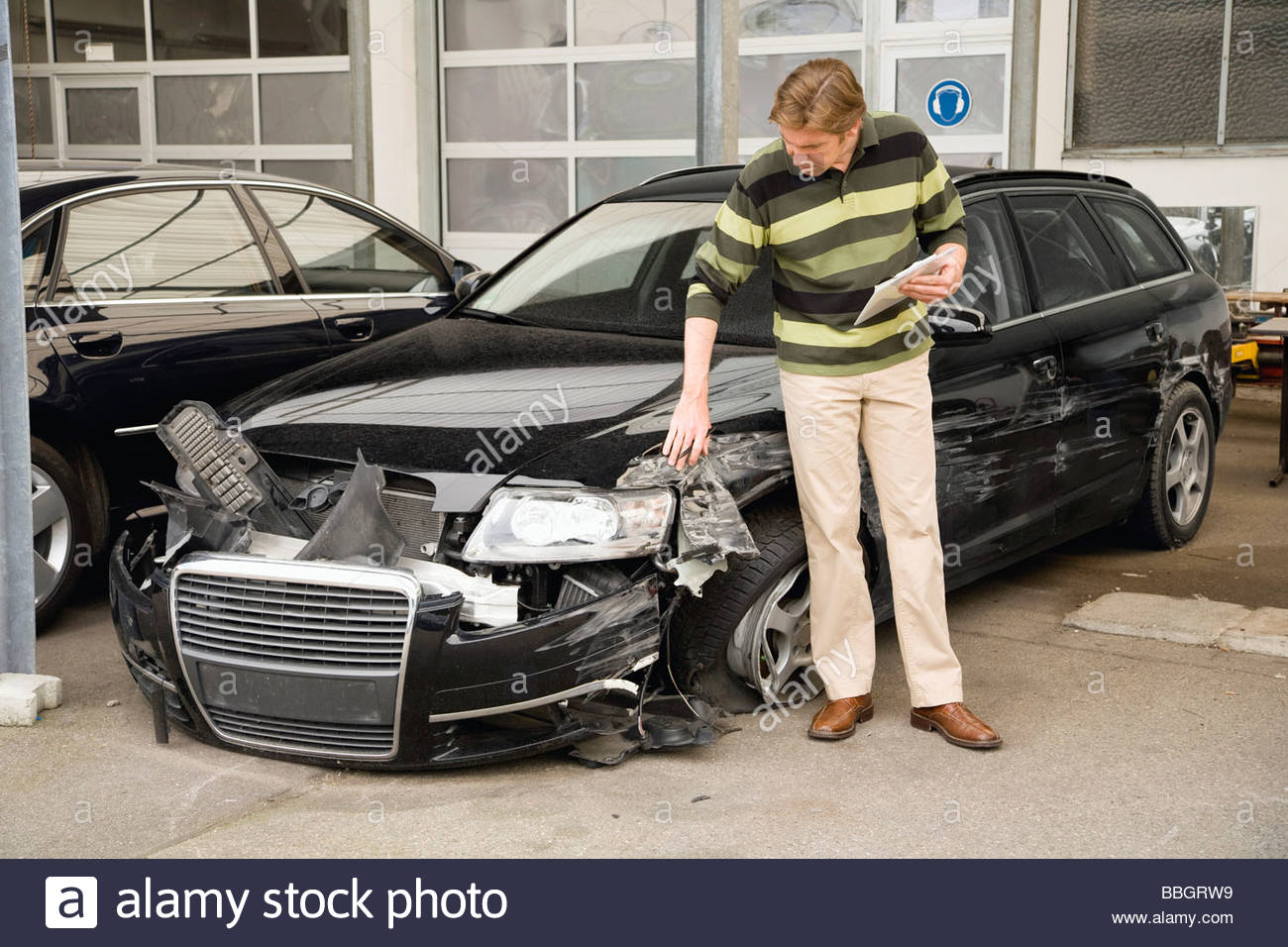 Insurance adjuster assessing damage to car Stock Photo, Royalty Free
