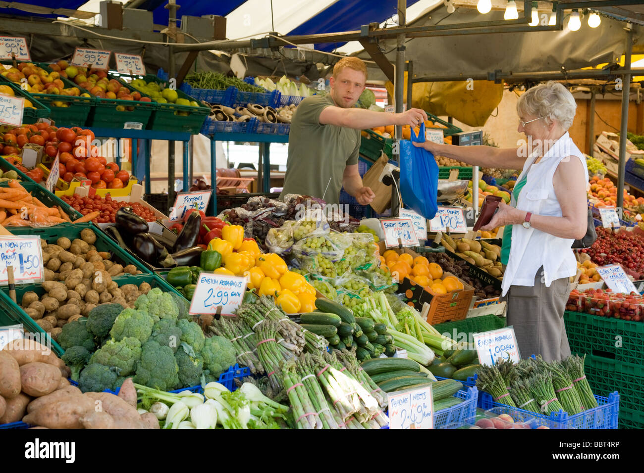 A customer buying groceries at a greengrocer stall, Cambridge market