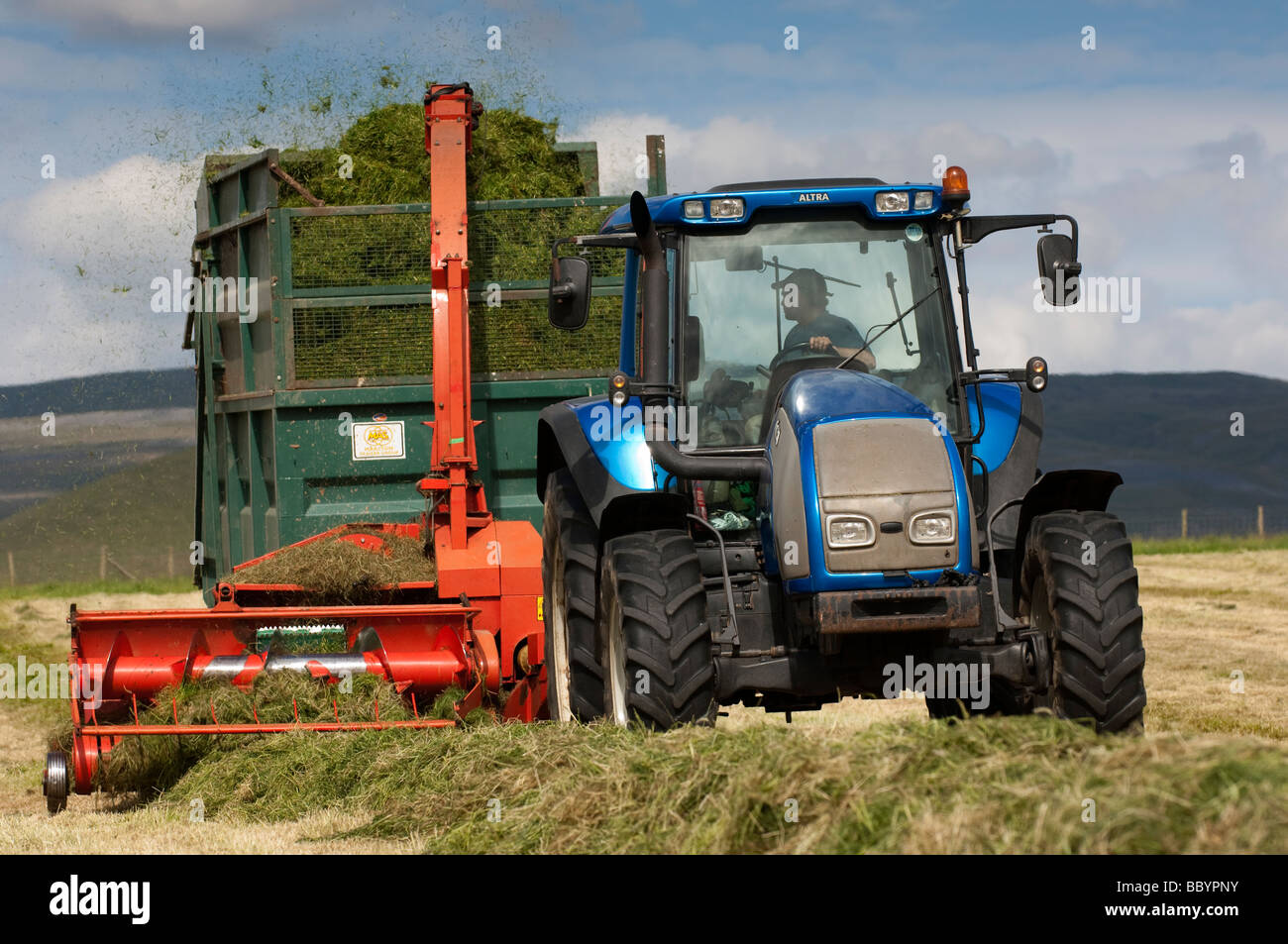 Valtra Tractor Pulling A Kverneland Forage Harvester And Trailer Making