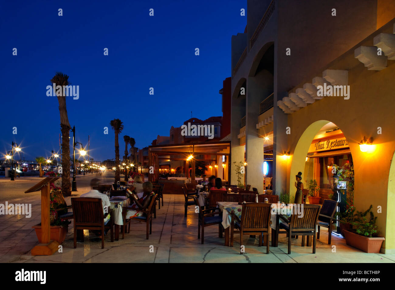 Street restaurant with people, evening, illuminated, marina Stock Photo