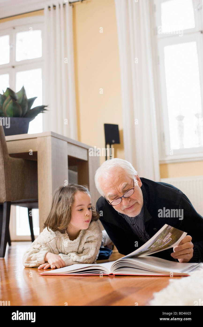 Old Man Reading Book To Young Gir