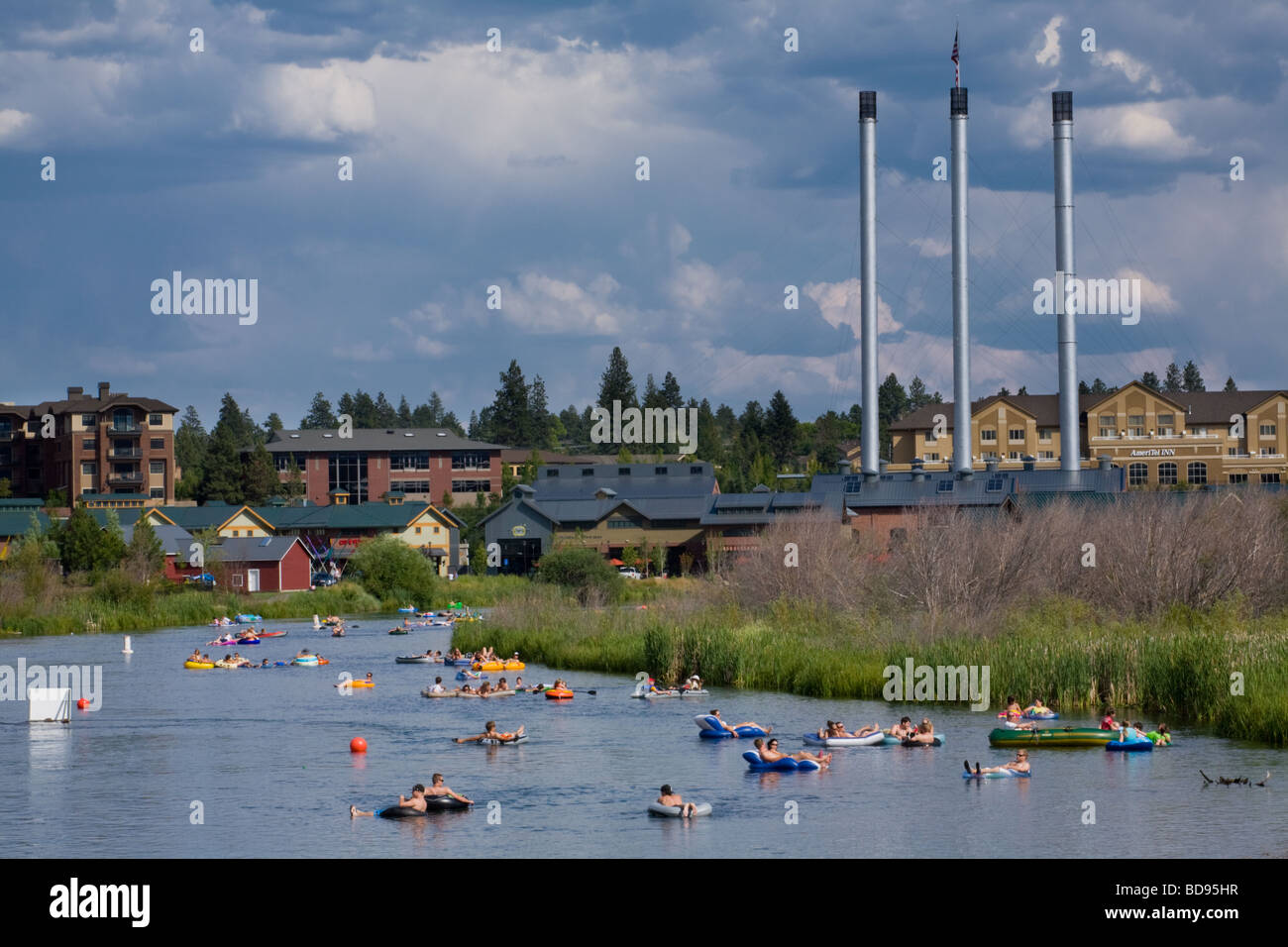 Many people leisurely floating on rafts down the Deschutes River Stock