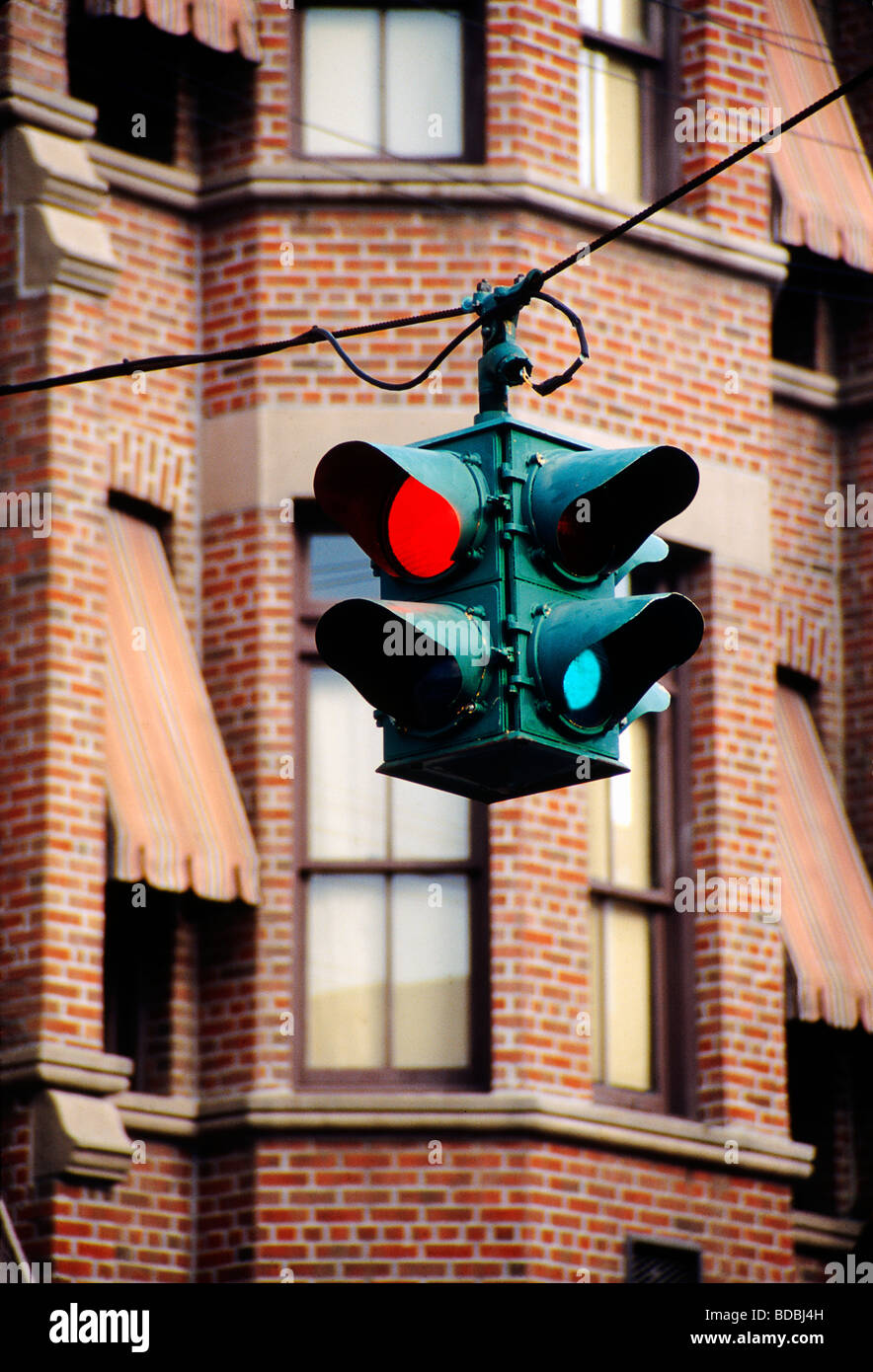 old-fashioned-traffic-light-hanging-from-cable-and-red-brick-building-BDBJ4H.jpg