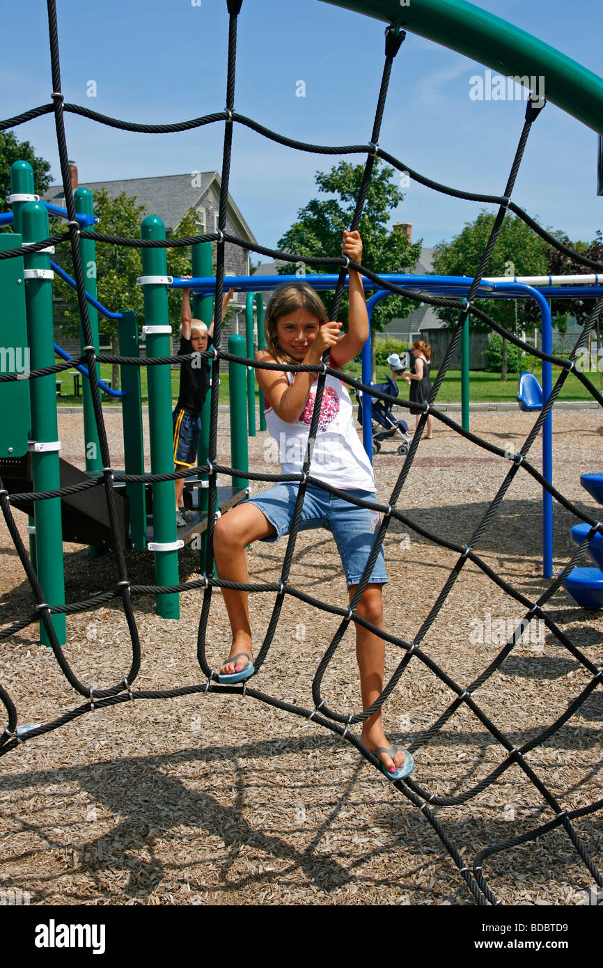 Girl climbing ropes at playground Stockfoto, Lizenzfreies Bild