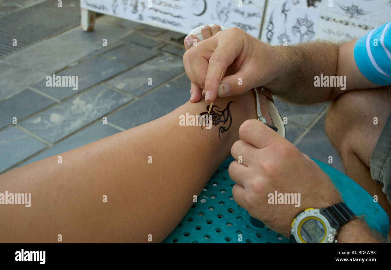 man applying henna tattoo to woman u0027s leg stock photo royalty free man applying henna tattoo to woman u0027s leg stock photo royalty free