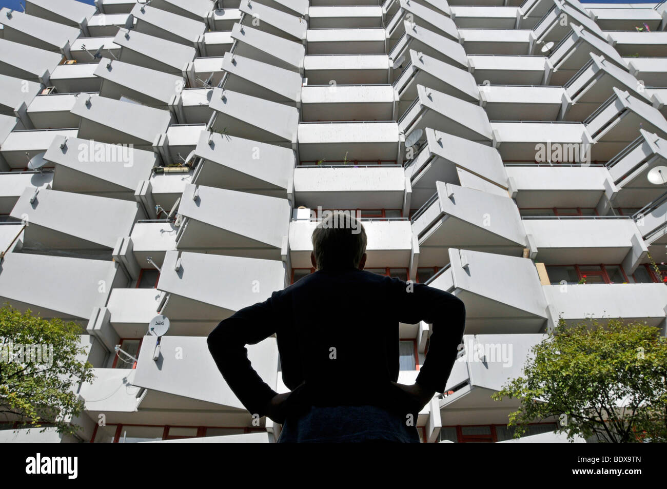 Apartment Building Front boy standing in front of a high-rise apartment building with stock Apartment Building Front boy standing in front of a high-rise apartment building with stock