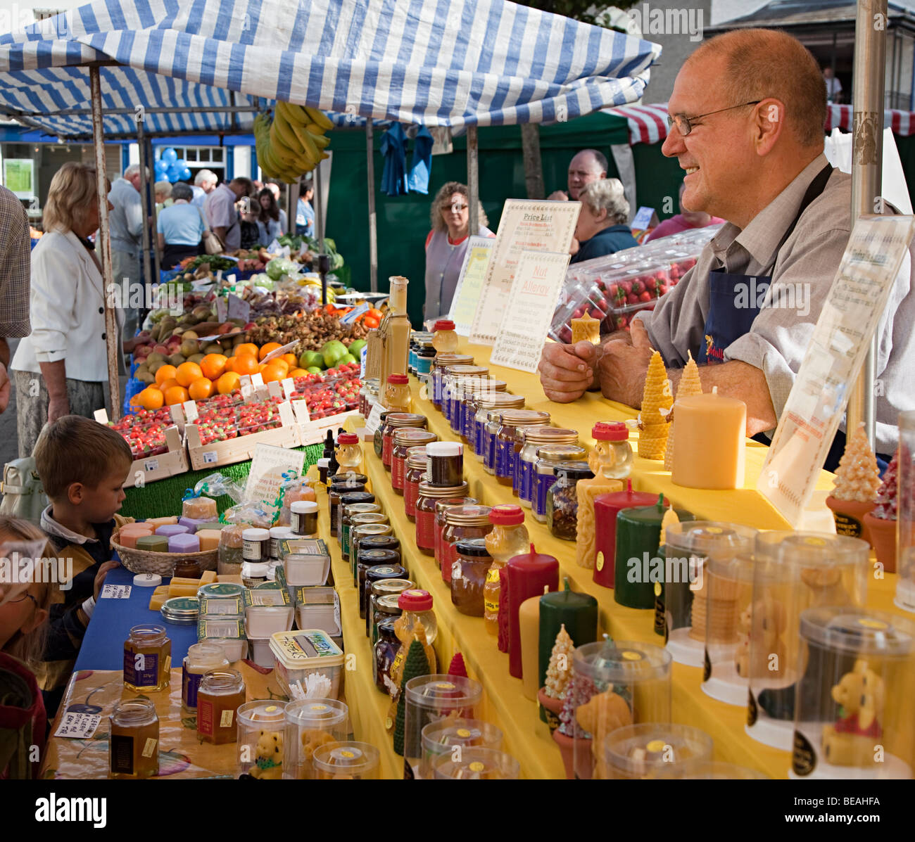 Man selling honey and beeswax products on market stall Abergavenny