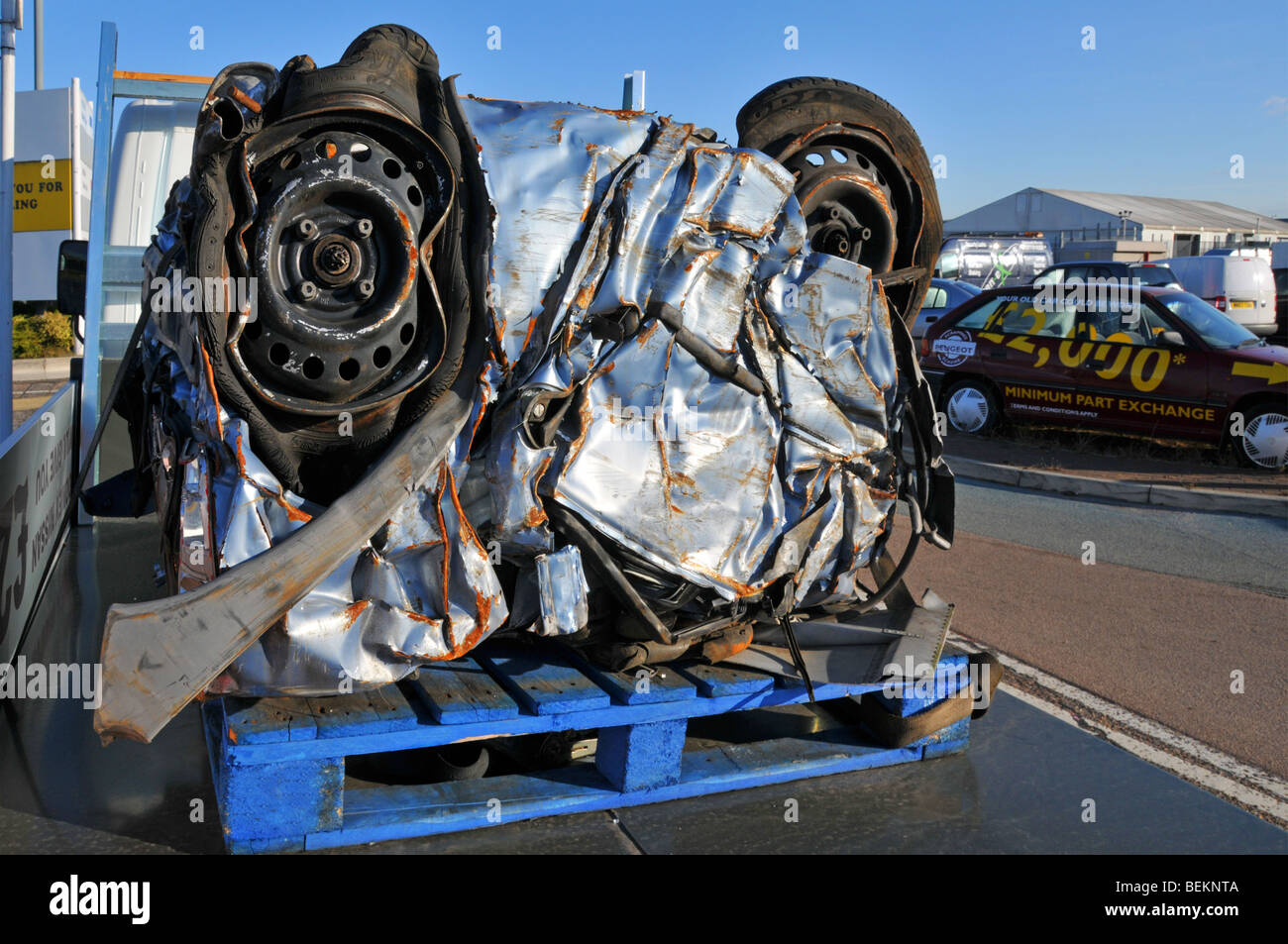 Scrapped motor car crushed into a cube for recycling in car dealers