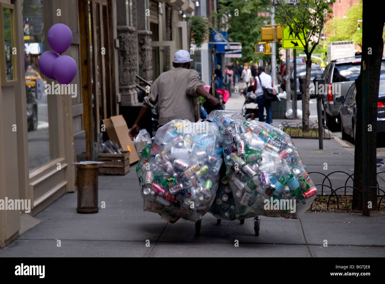 Homeless man in NYC collecting cans to take to recycle and get money