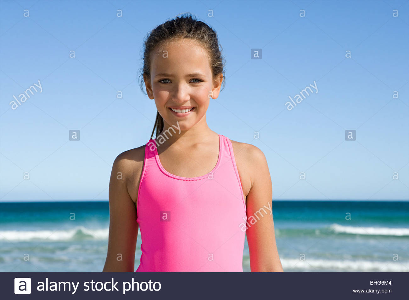 Portrait of little girl at the beach in bright pink swimsuit Stock