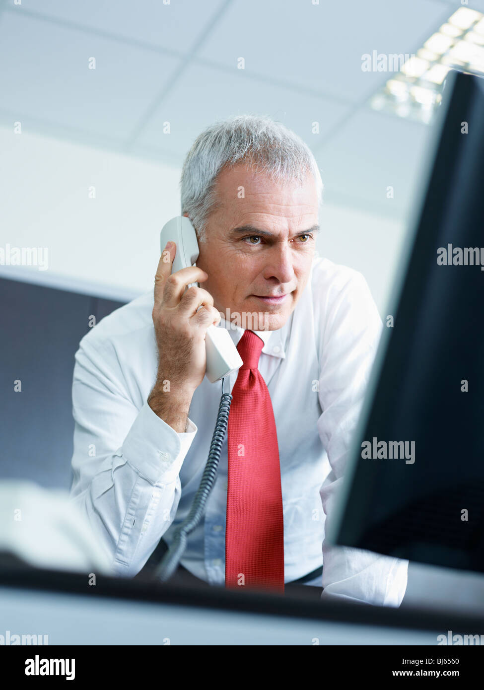 Portrait Of Mature Business Man Talking On The Phone Looking At