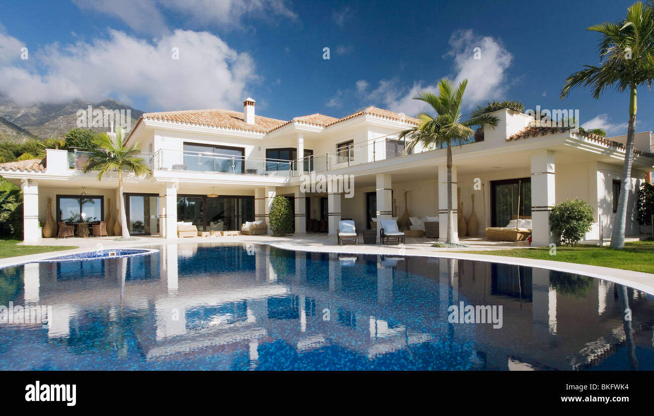 Stock photo swimming pool in front of large modern white spanish villa