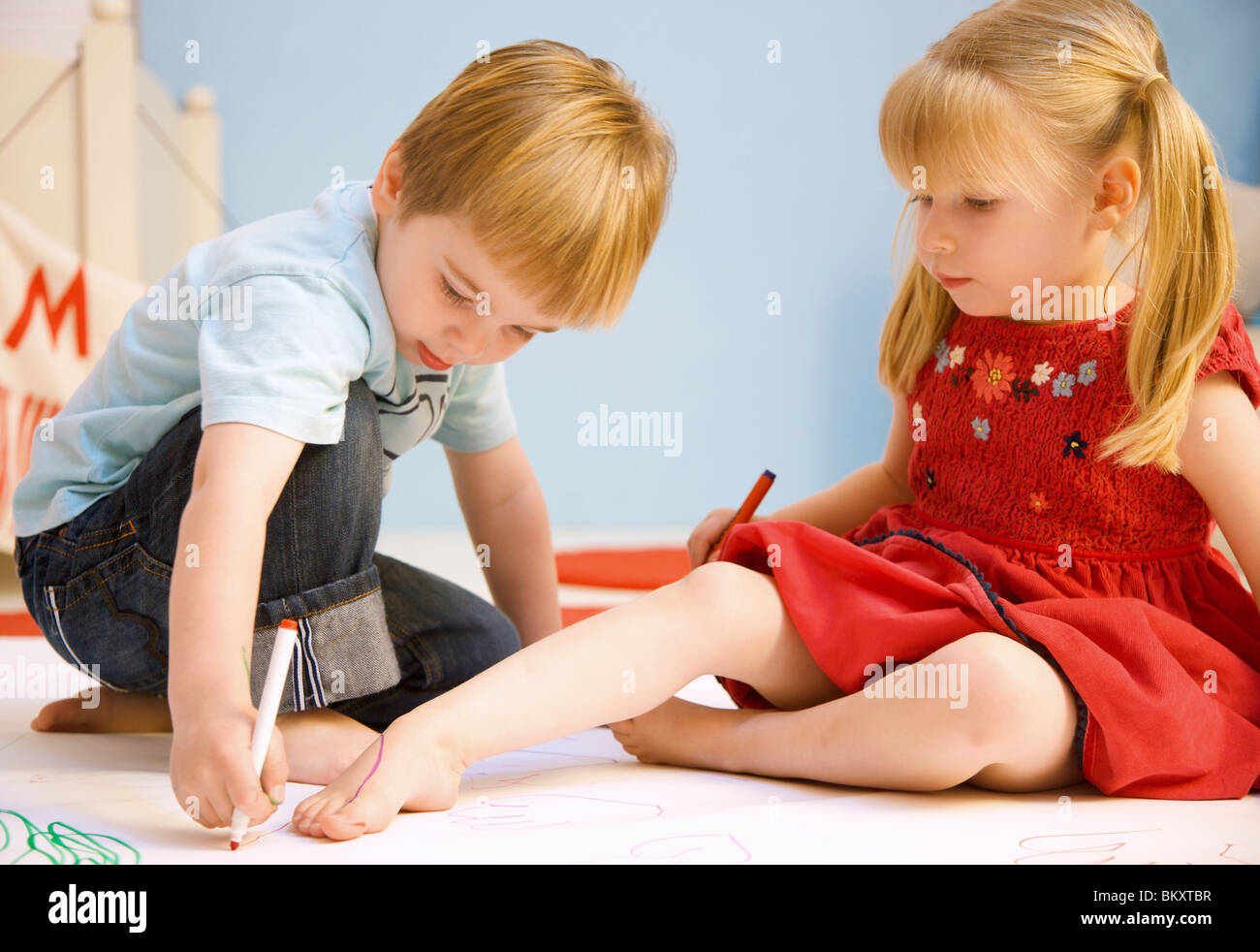 Boy Drawing The Outline Of A Girl Foot Stock Photo Royal