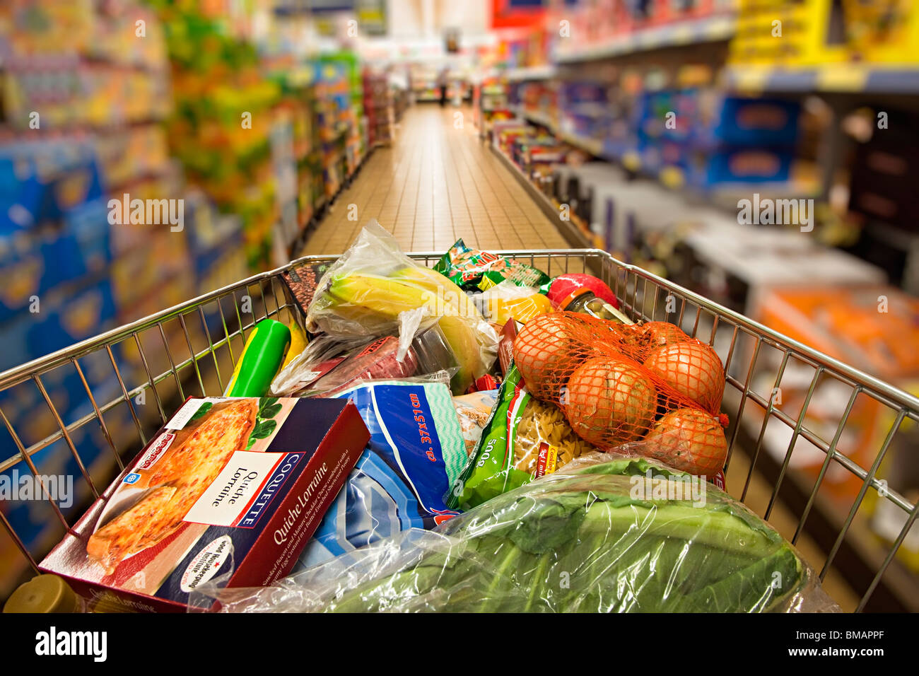 Shopping trolley being pushed down Lidl supermarket aisle Wales UK