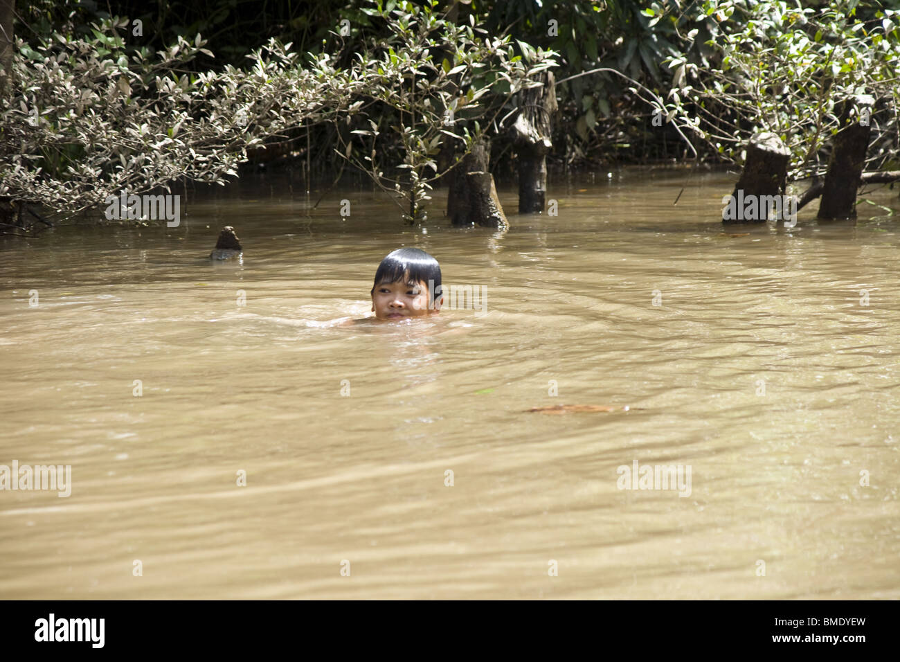 Small boy swimming in dirty river, Vietnam Stock Photo, Royalty Free