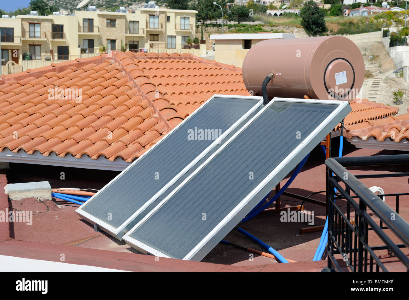 A solar water heating panel with water tank on the roof of a villa in Stock Photo, Royalty Free