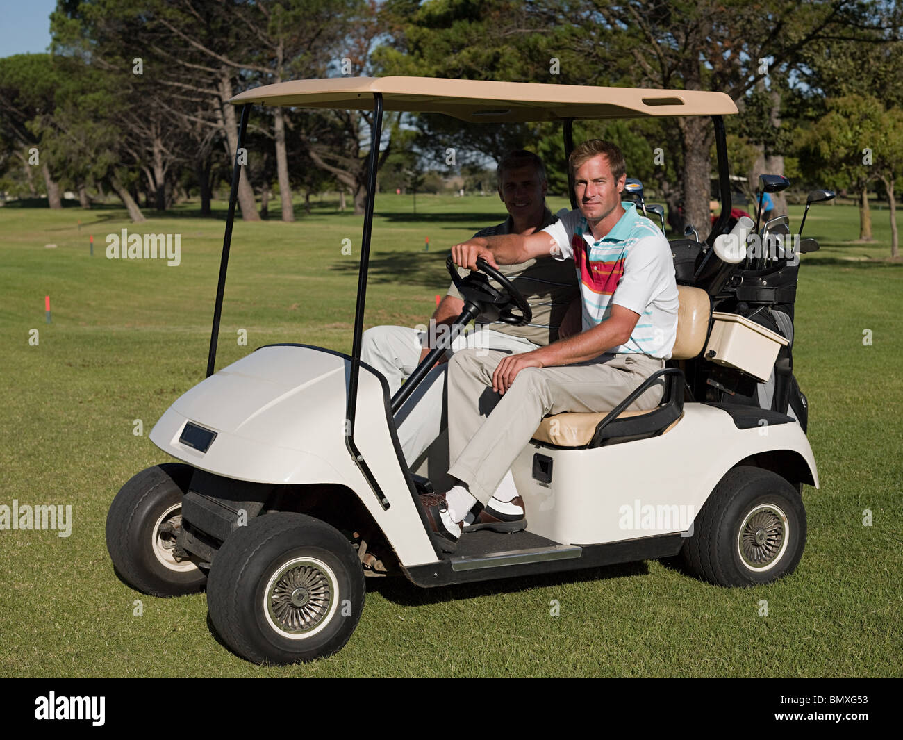 Two mature men in golf cart on golf course Stock Photo, Royalty Free