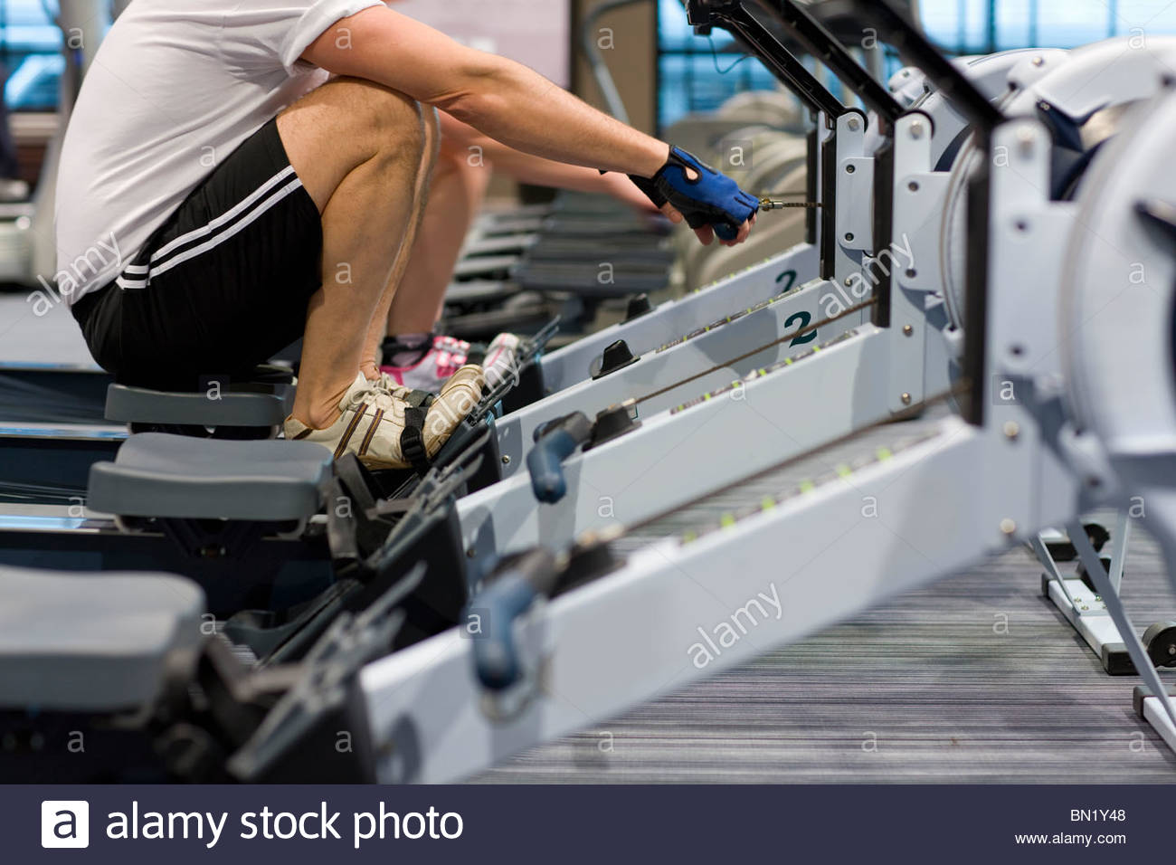 man-working-out-on-rowing-machine-in-hea