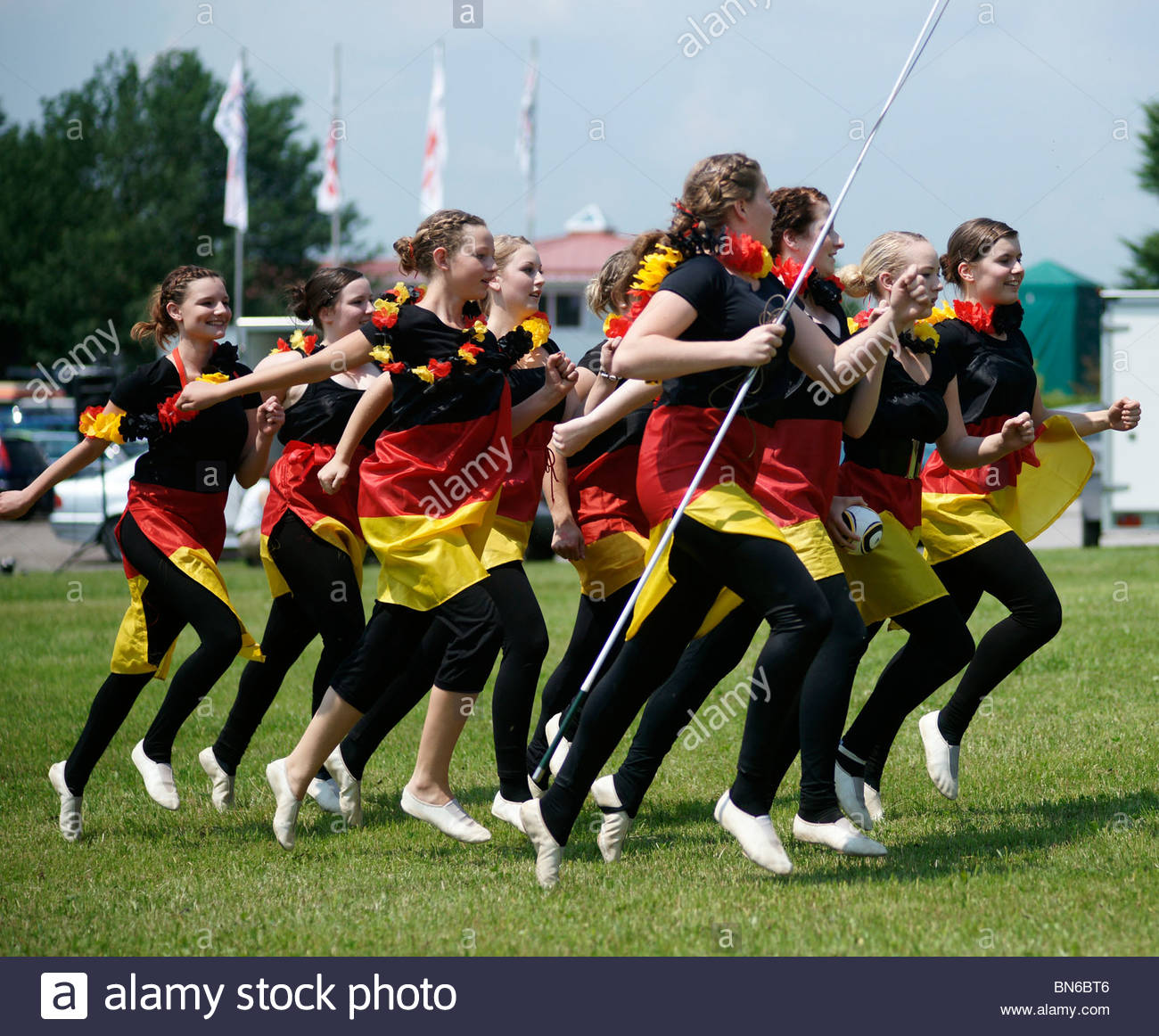 German schoolgirls running at a rural event wearing costumes of Stock