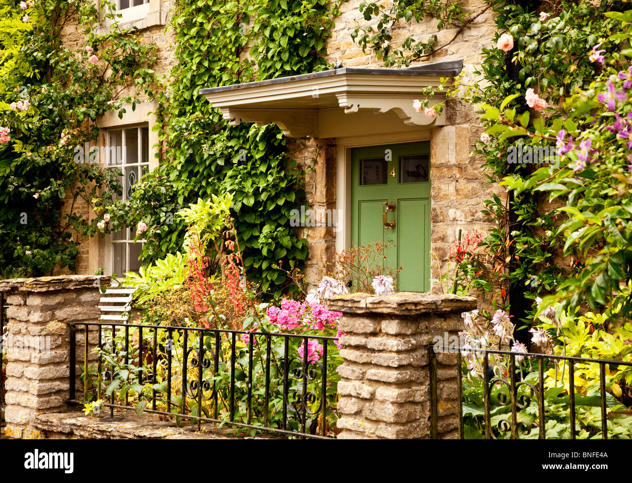 Pretty summer front garden of a typical Cotswold stone house in the